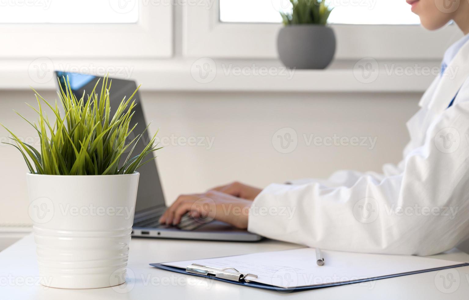 irreconhecível médico trabalhando dentro gabinete em laptop.online consulta ou webinars conceito foto