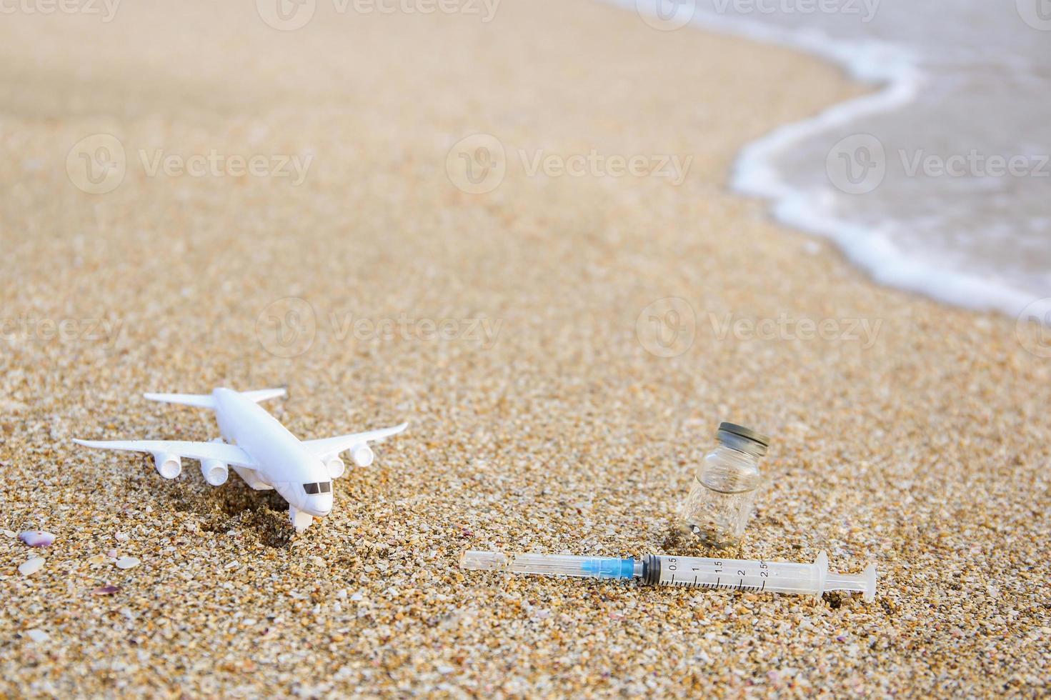 vacina contra COVID-19, seringa, avião em de praia. foto