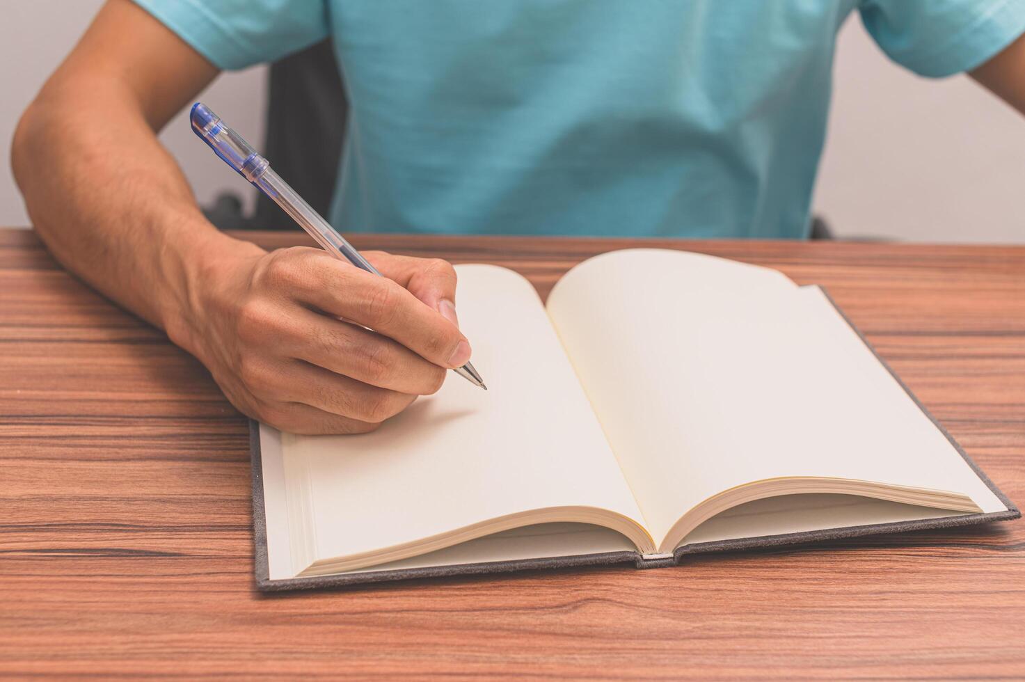 pessoa escrevendo um livro em uma mesa foto