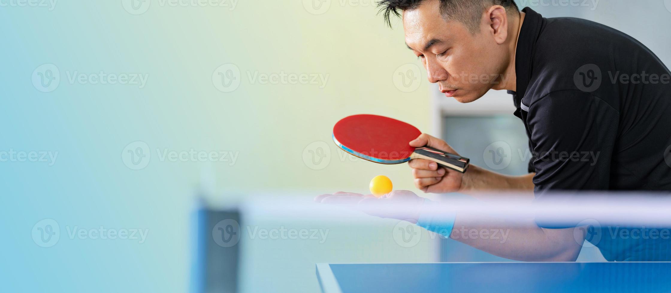 masculino jogando tênis de mesa com raquete e bola em um ginásio esportivo foto