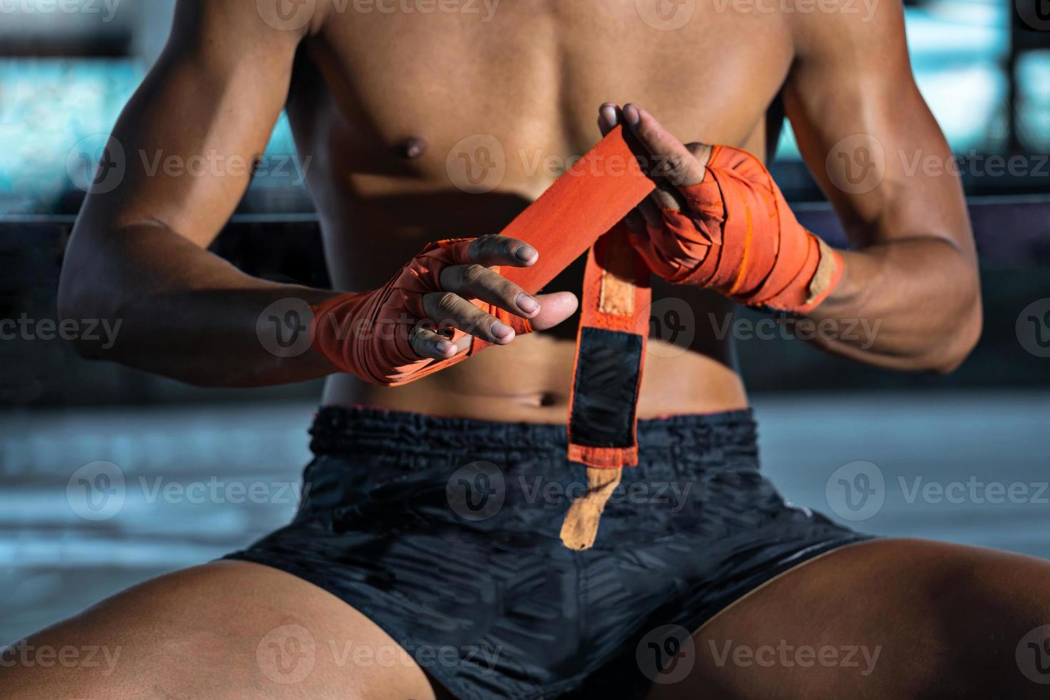 lutador amarrando fita adesiva antes da luta, boxe tailandês foto