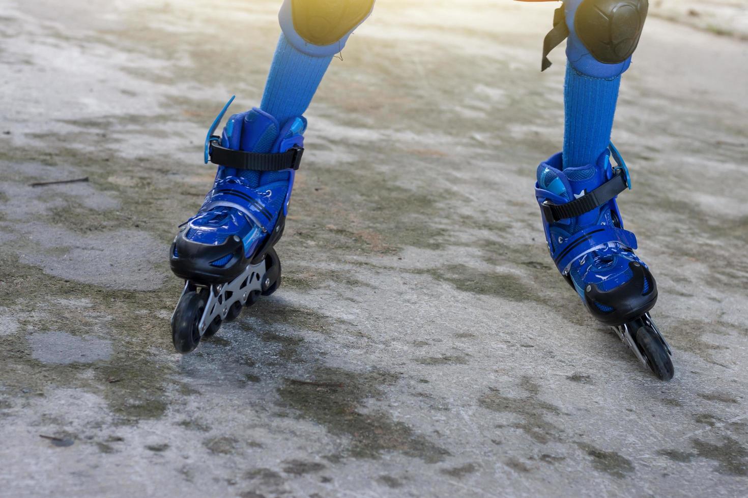 pequeno Garoto Aprendendo rolo patim de vestindo azul rolo patim sapatos e joelho almofadas para seguro. foto