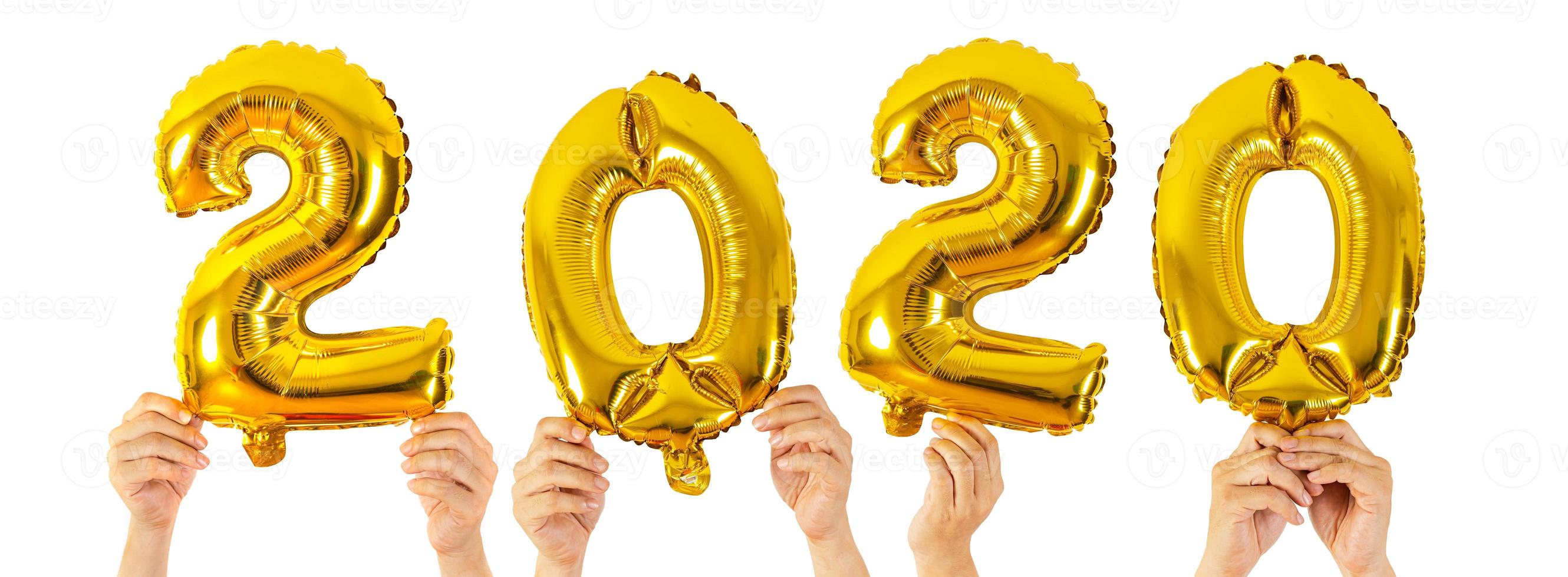 mãos segurando balões com números de 2020 em fundo branco foto