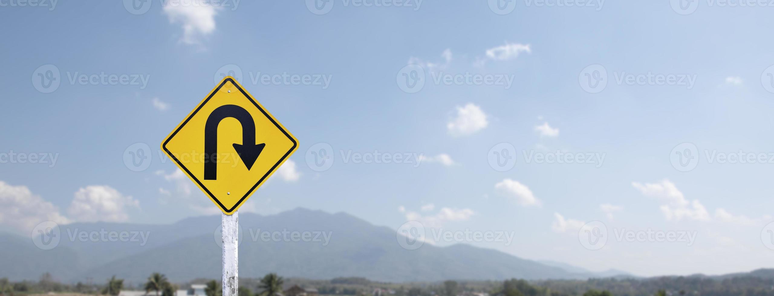 sinal de trânsito, vire à direita no poste de cimento ao lado da estrada rural com fundo azul nublado branco, copie o espaço. foto