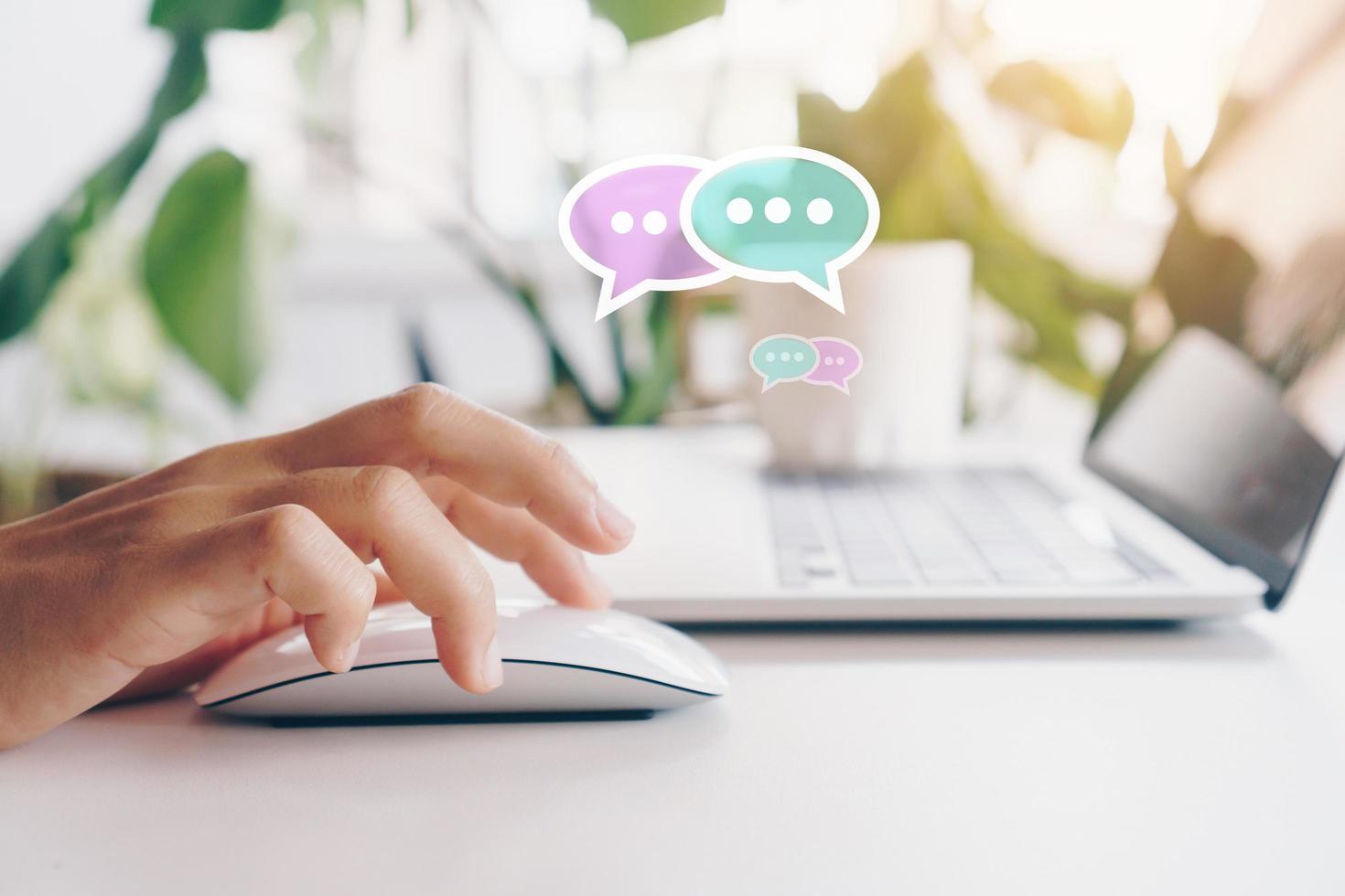 mão digitando em um teclado com ícones de comunicação foto