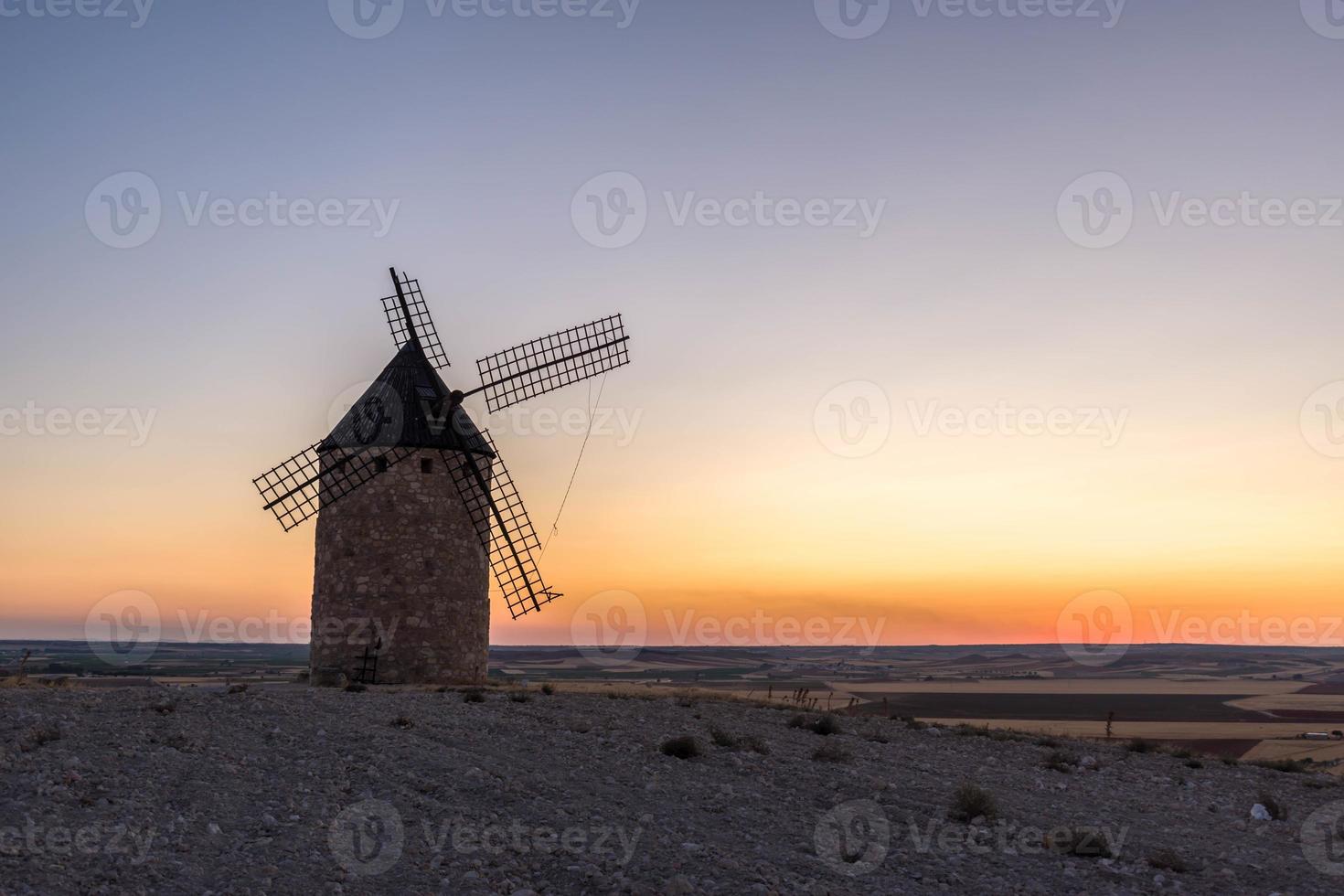 velho moinho de vento ao pôr do sol foto