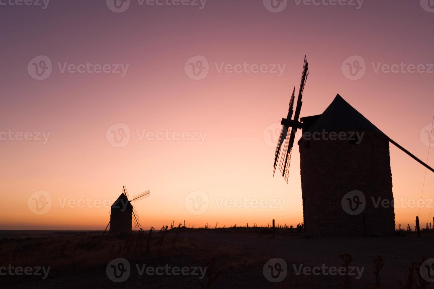 velhos moinhos de vento ao pôr do sol foto