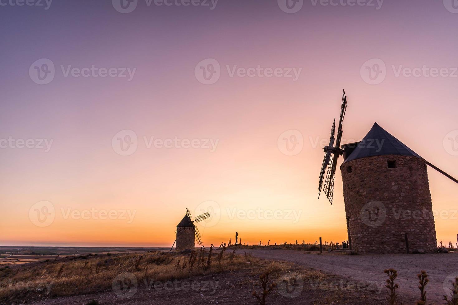 velhos moinhos de vento ao pôr do sol foto