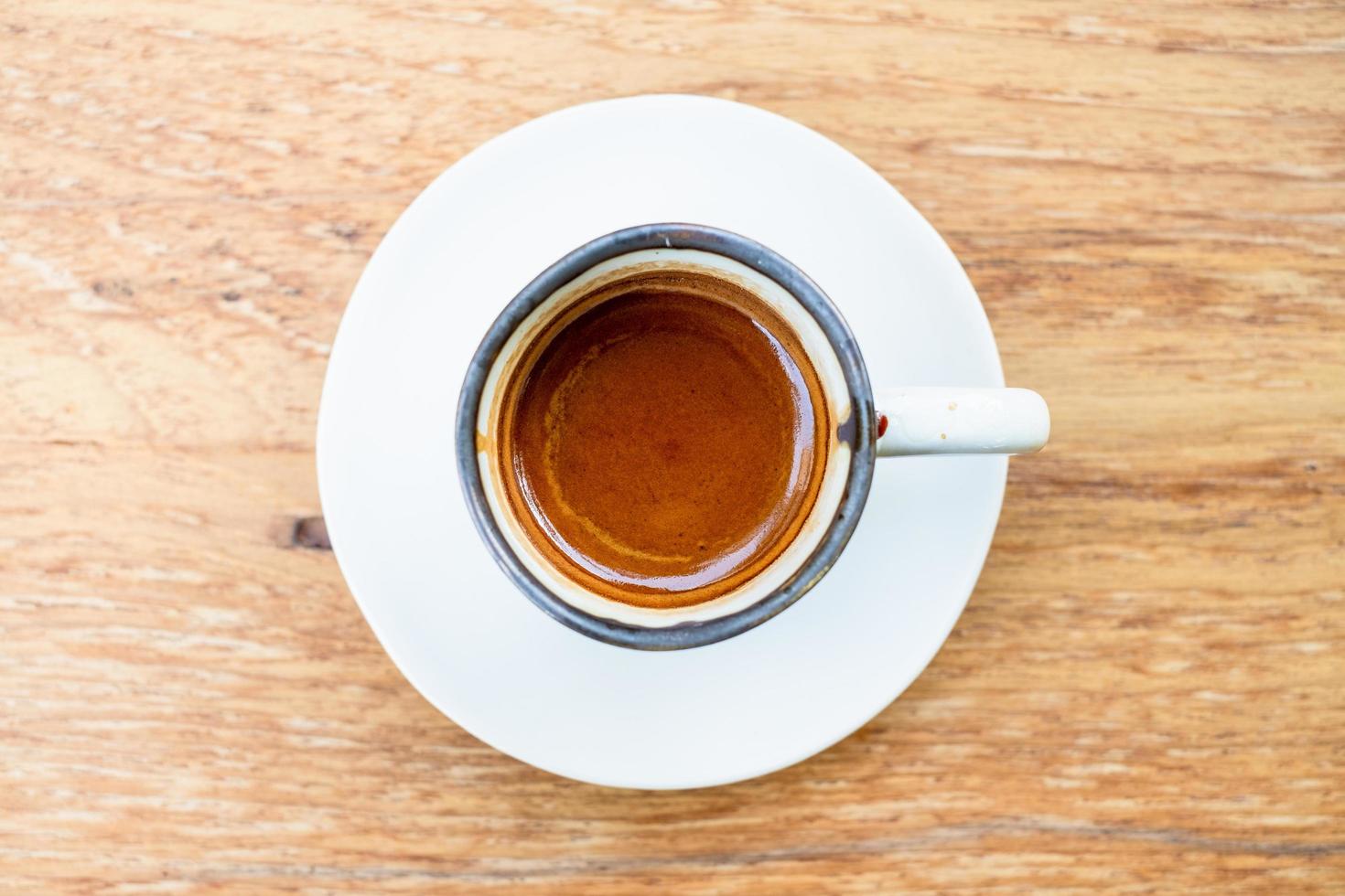 uma xícara de café expresso quente em um fundo de madeira foto