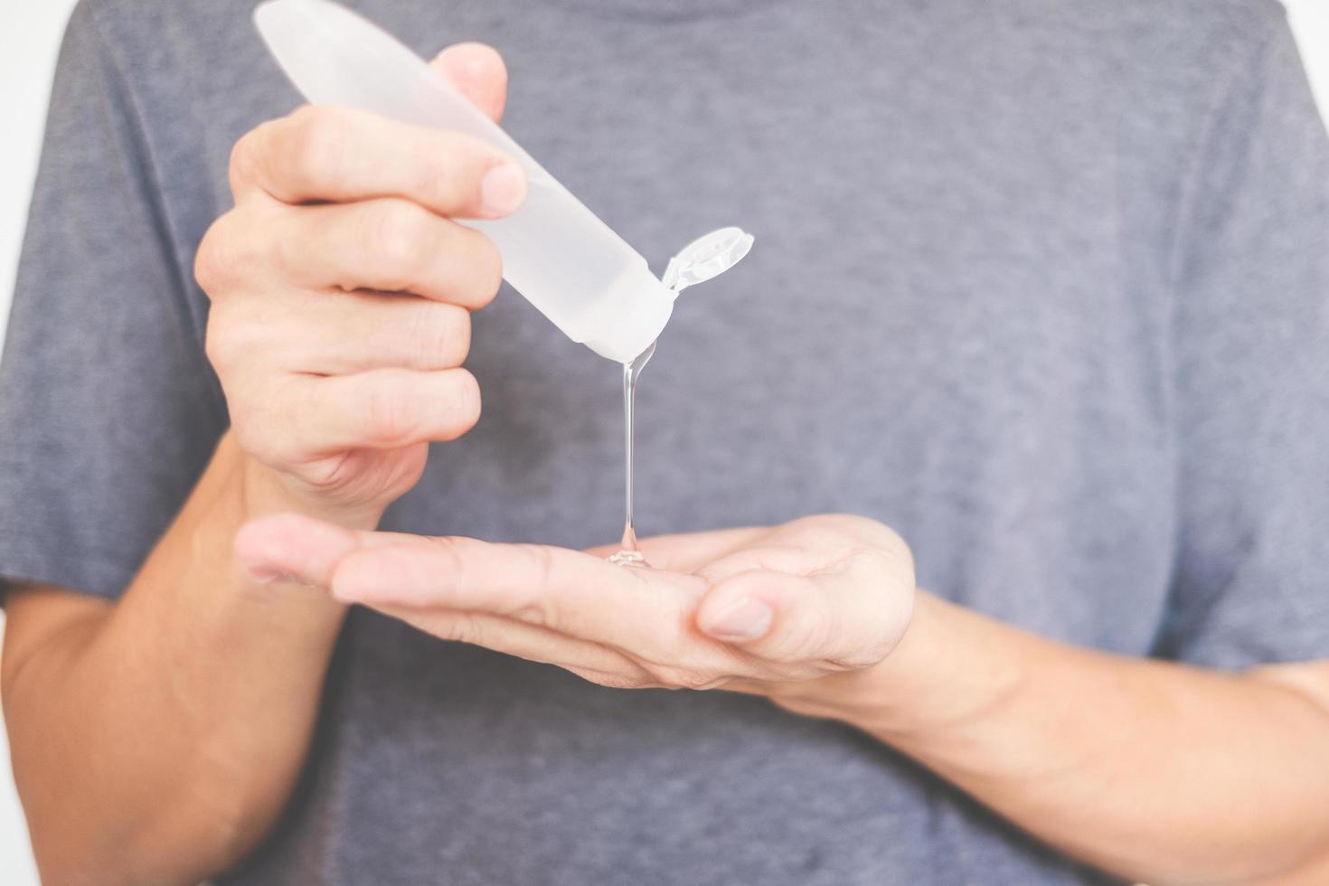 mãos de homem usando dispensador de gel desinfetante para as mãos contra o novo coronavírus ou covid-19, conceito de higiene e saúde foto