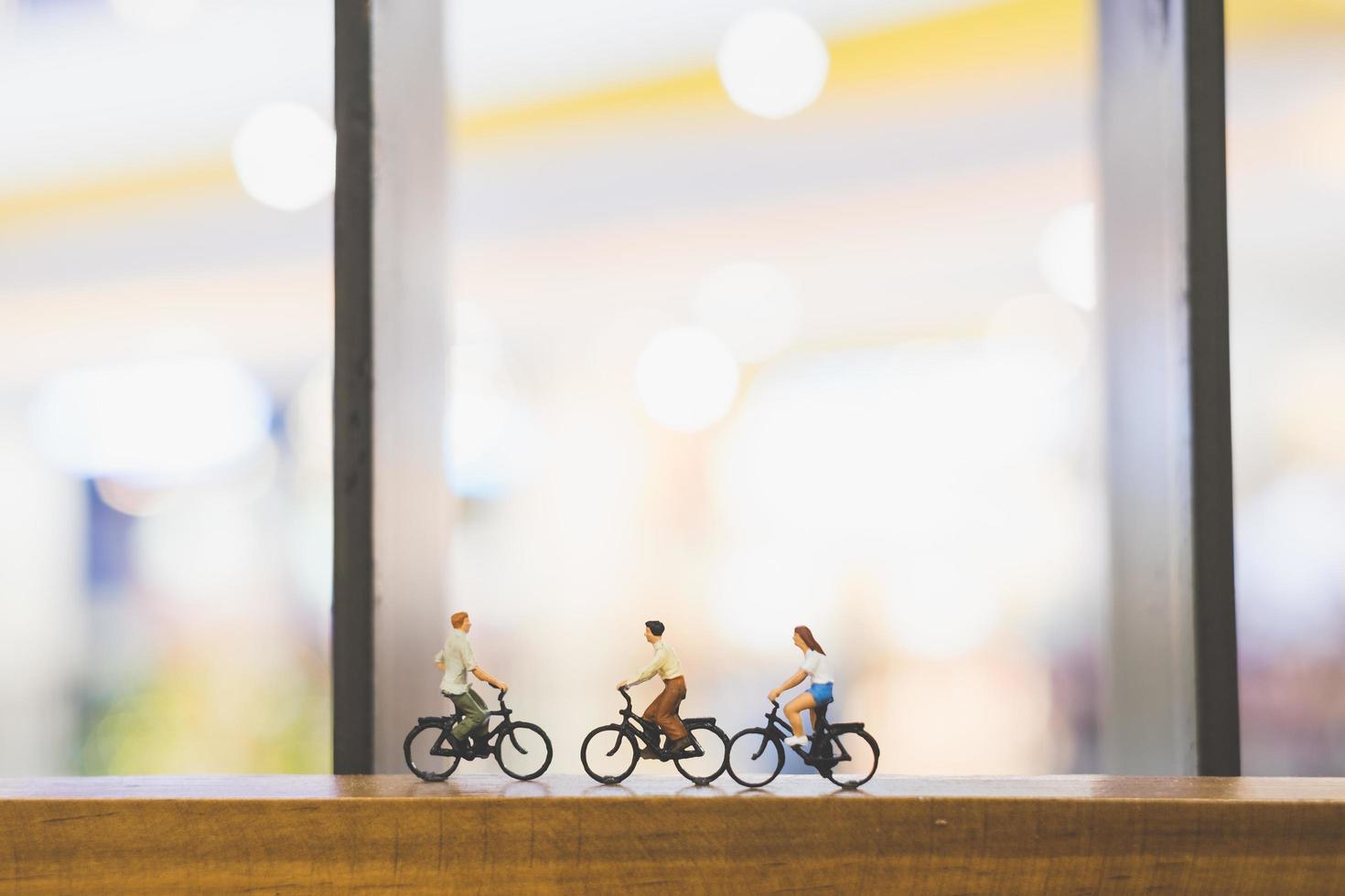 viajantes em miniatura com bicicletas em uma ponte de madeira foto