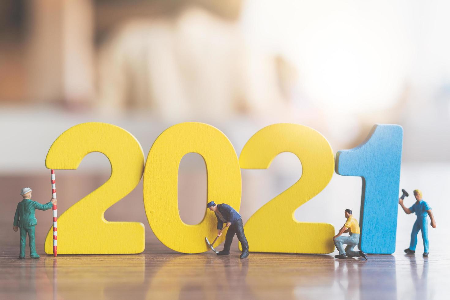 trabalhadores em miniatura construindo números de madeira 2021, conceito de feliz ano novo foto