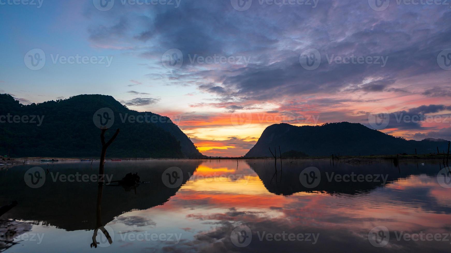 vista do nascer do sol com reflexo das montanhas em klong hua chang reservior, phatthalung, tailândia foto