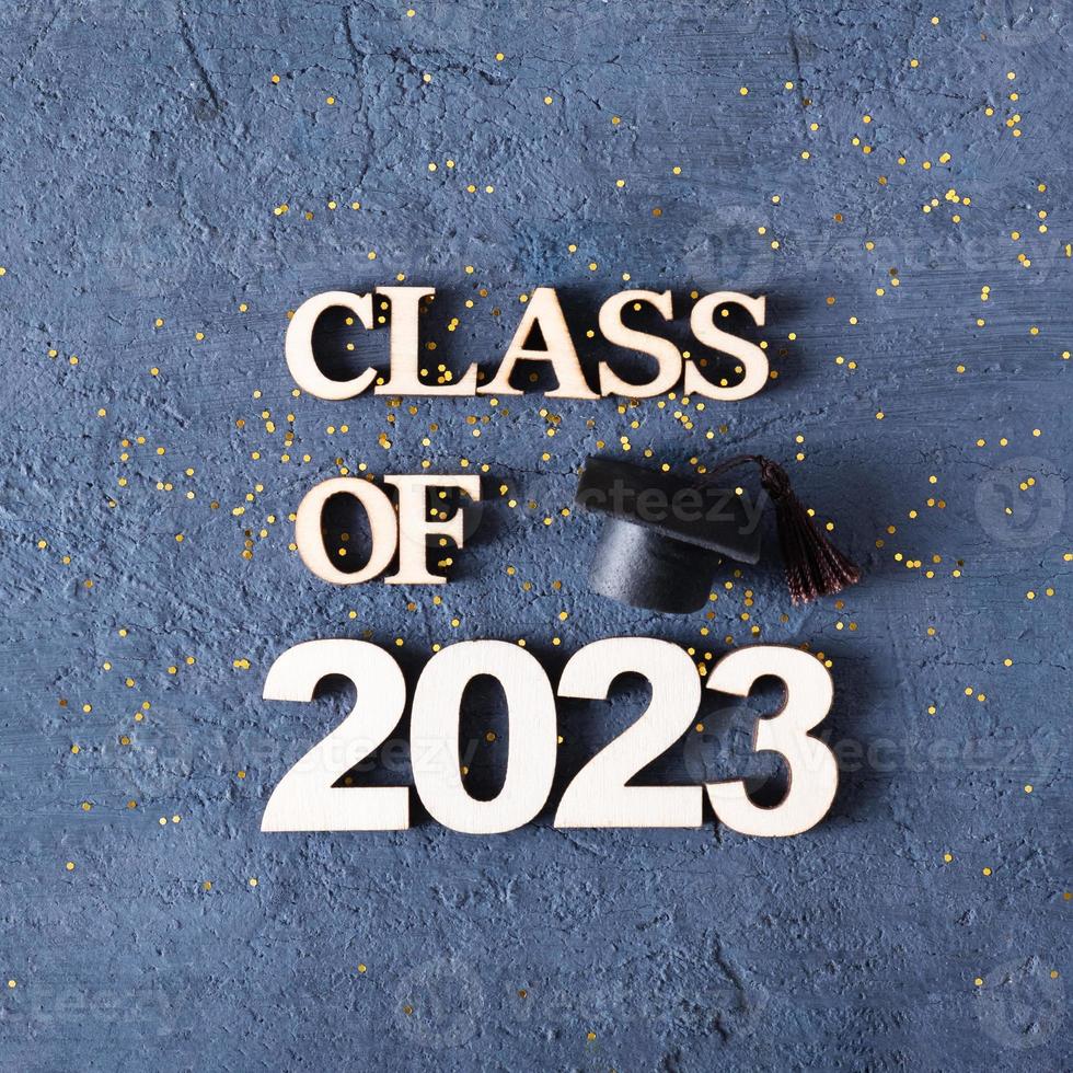 classe do 2023 conceito. de madeira número 2023 com graduado boné em Sombrio concreto fundo com ouropel foto