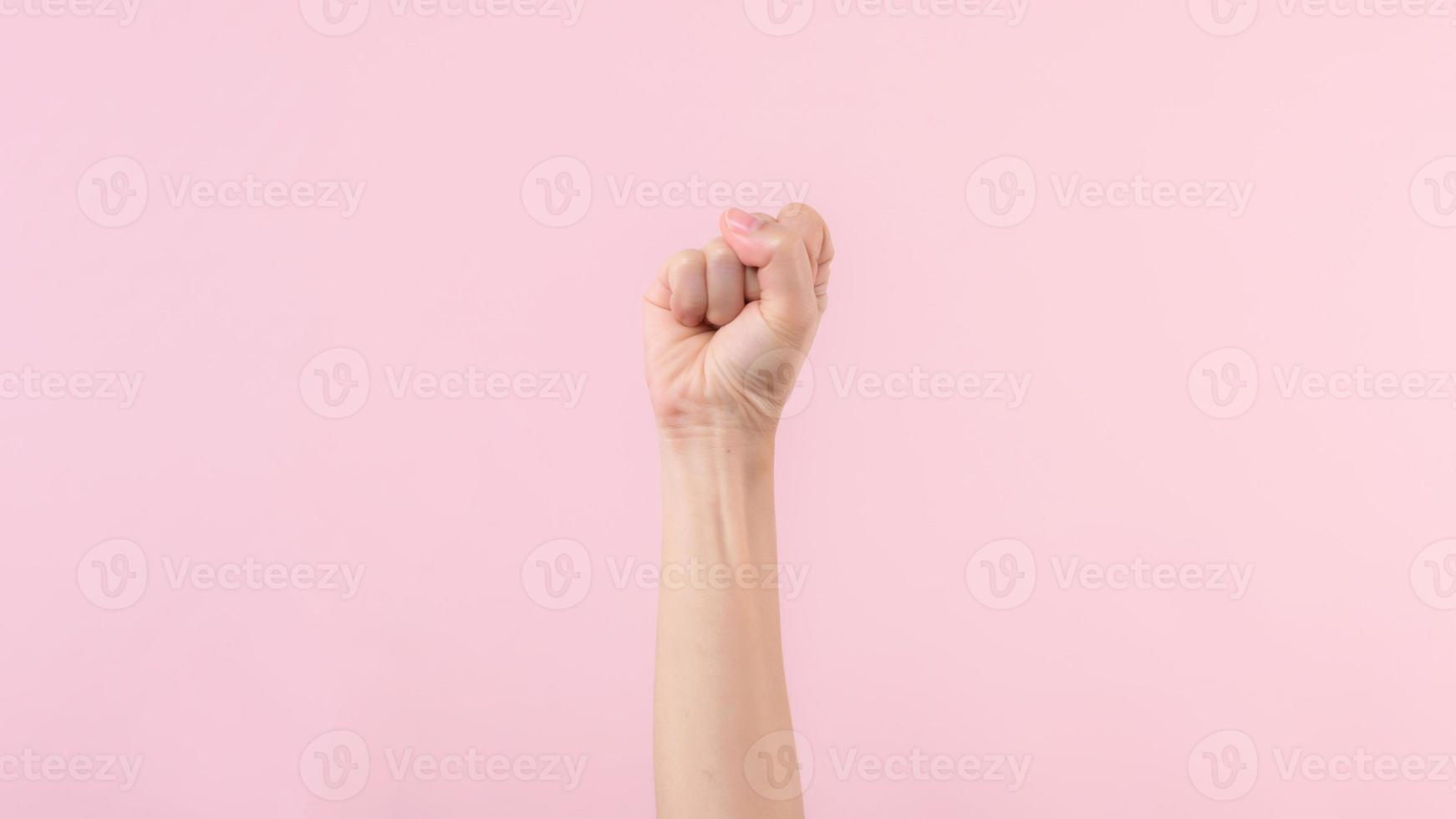 mulher punho luta para humano direitos e feminista com Rosa pastel fundo. mulheres fortalecimento, igualdade, força e coragem conceito foto