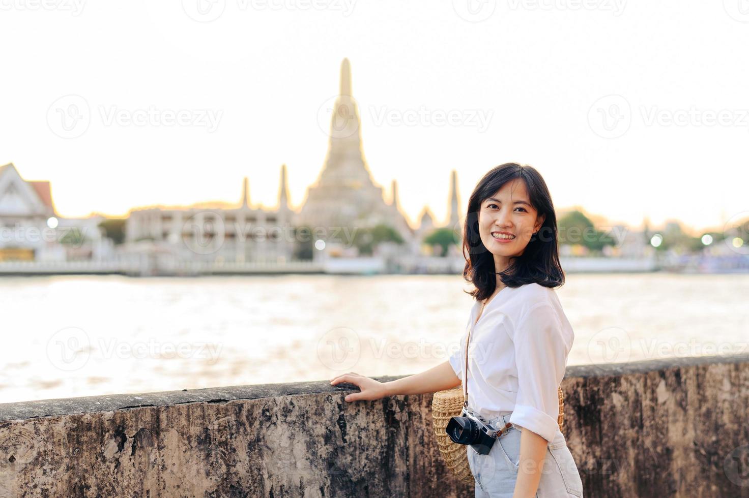 retrato jovem lindo ásia mulher sorridente enquanto viagem às wat uma corrida pôr do sol Visão apontar, Bangkok, tailândia. foto