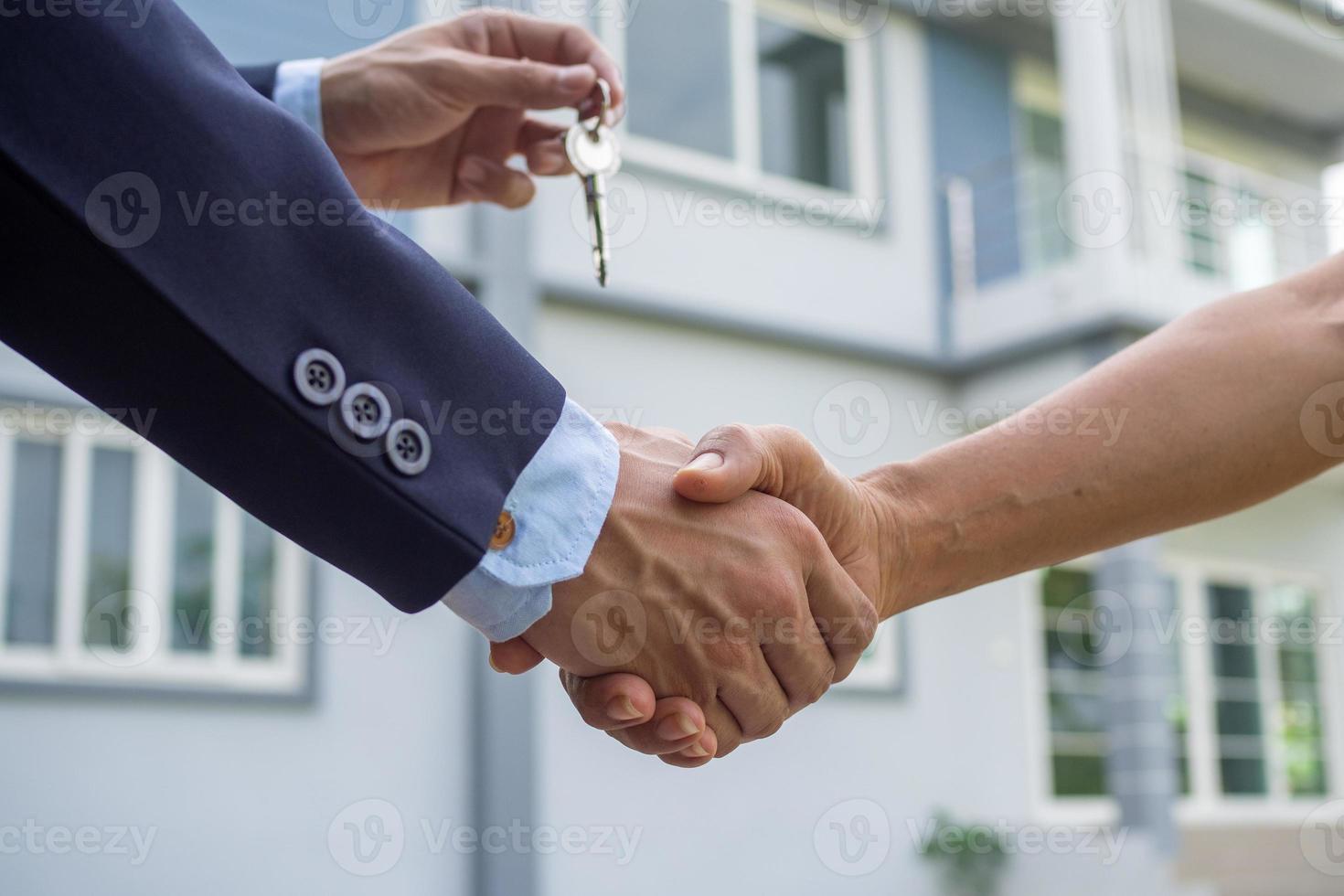 agente vende a casa mexe mão com a comprador e mandar casa chave para a comprador. foto