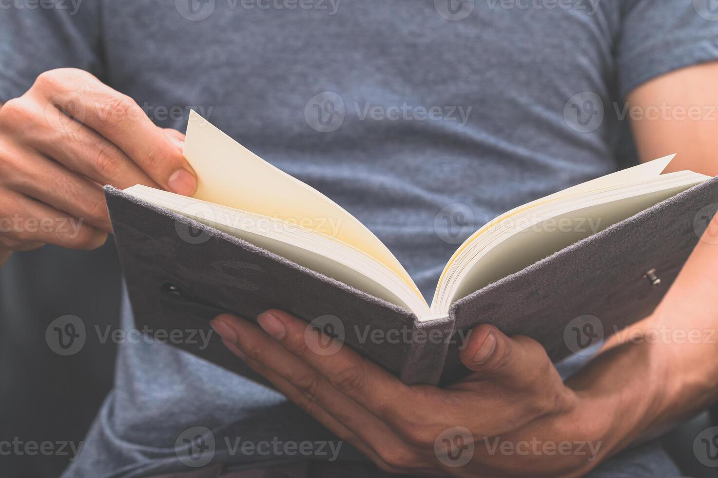 um homem escrevendo em um caderno foto