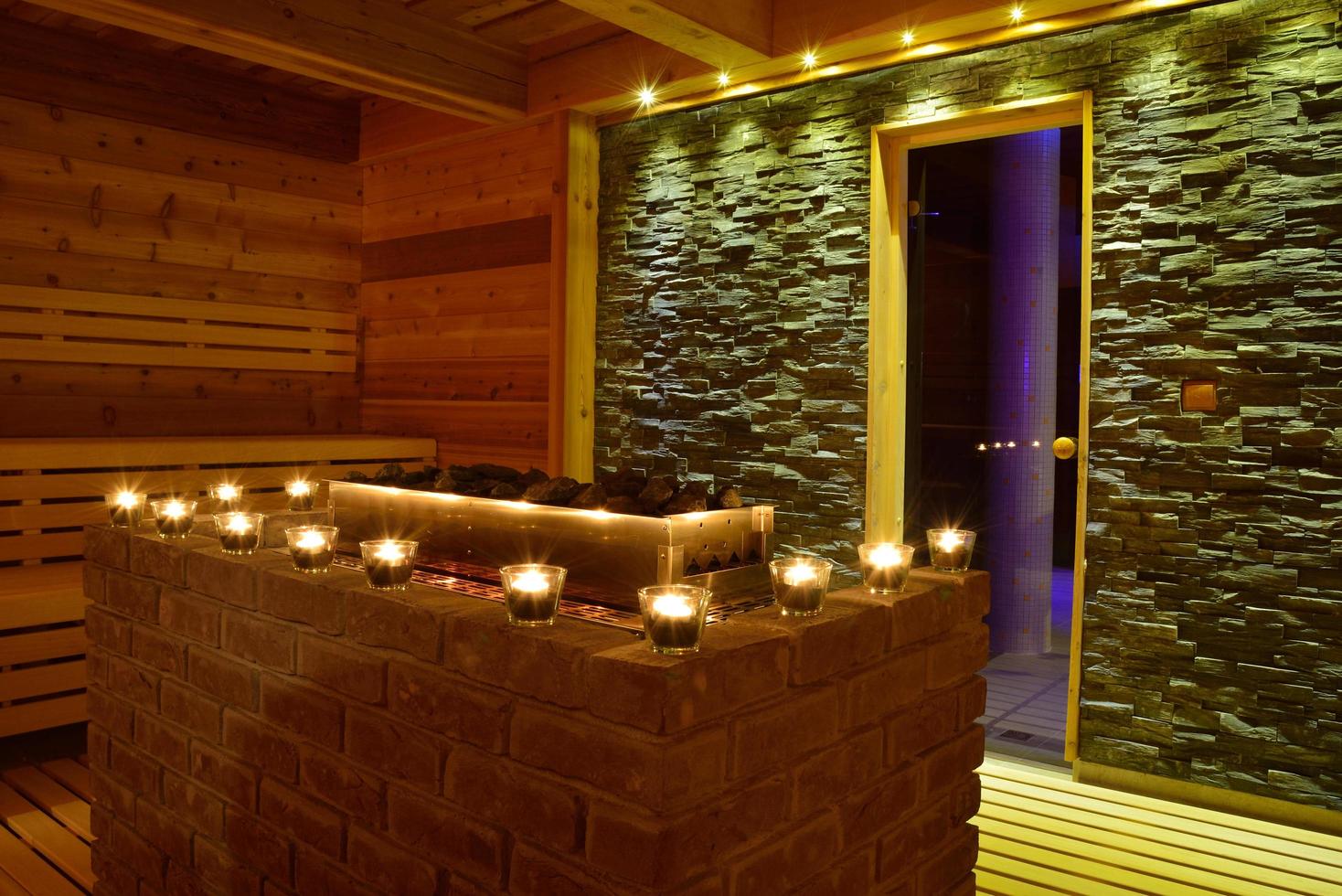 sauna moderna com velas e interior em pedra foto