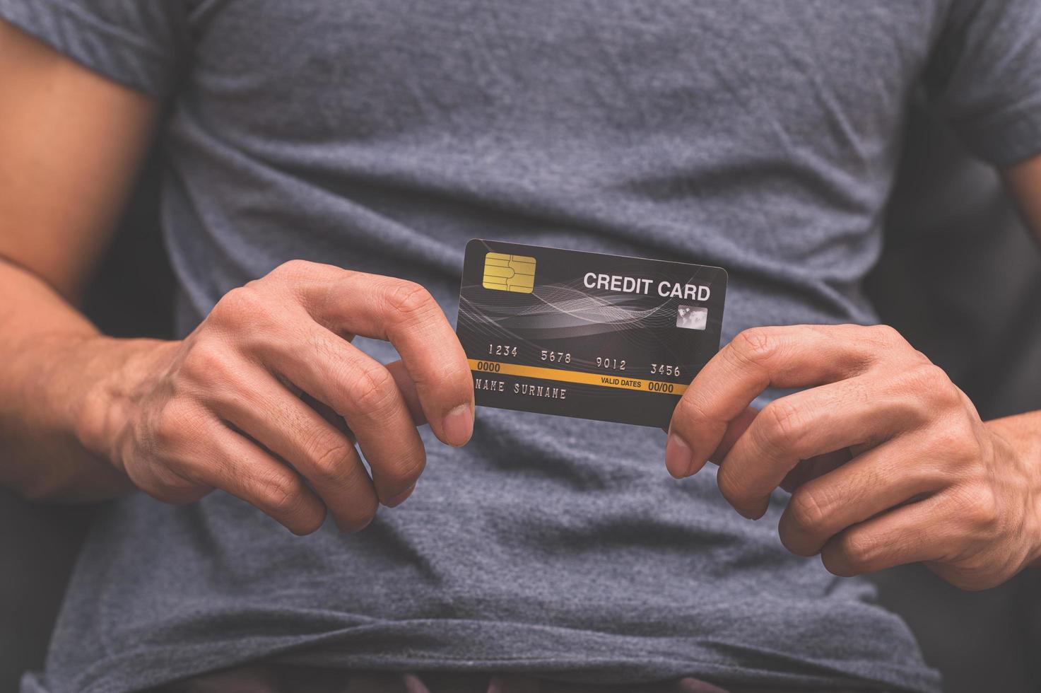um homem segurando um cartão de crédito na mão foto