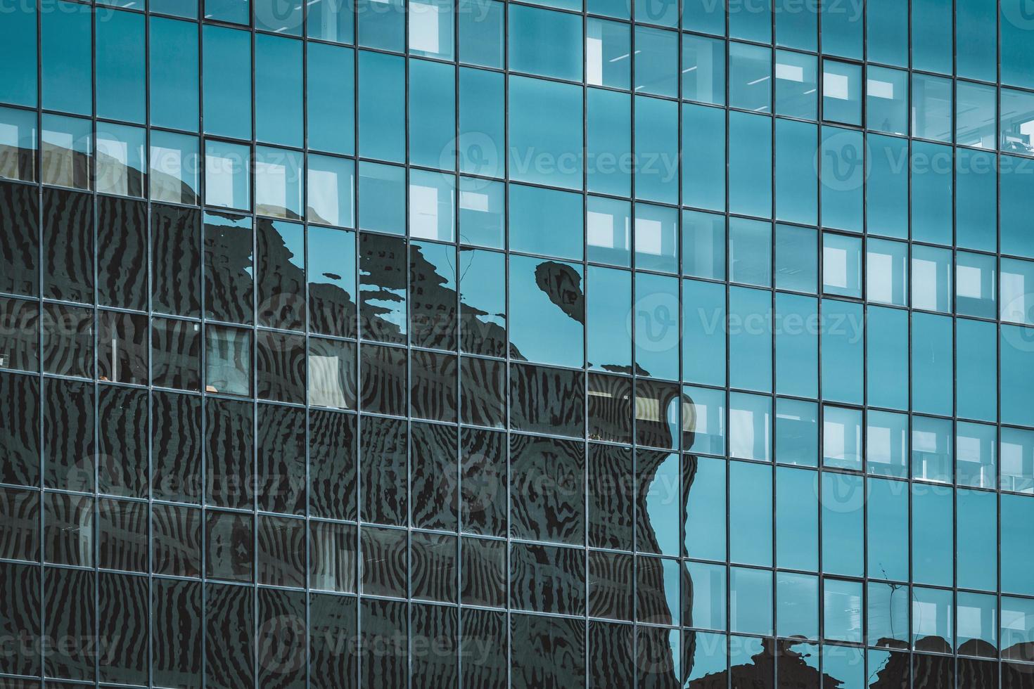 reflexos na fachada envidraçada de um prédio de escritórios foto