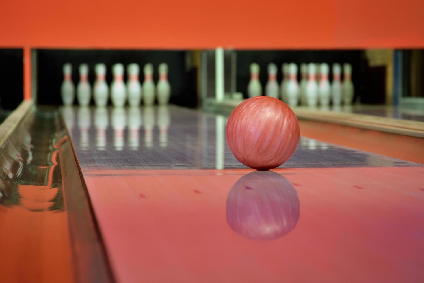 bola de boliche vermelha na pista no centro de boliche foto