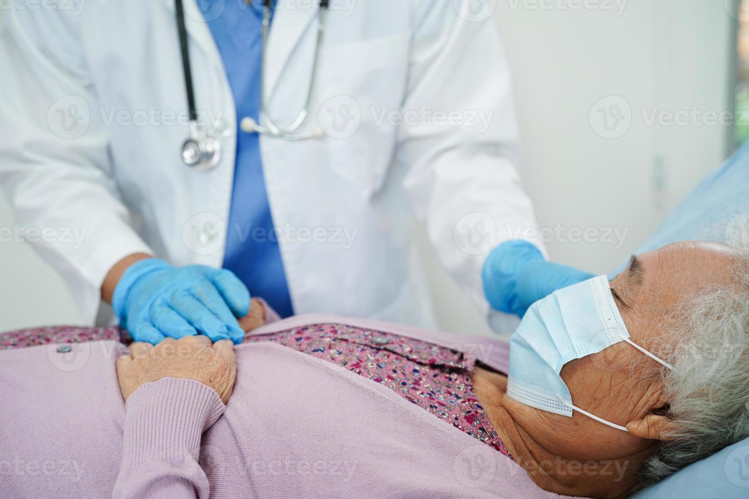 médico cuidando, ajudando e incentivando a paciente idosa asiática idosa no hospital clínico. foto