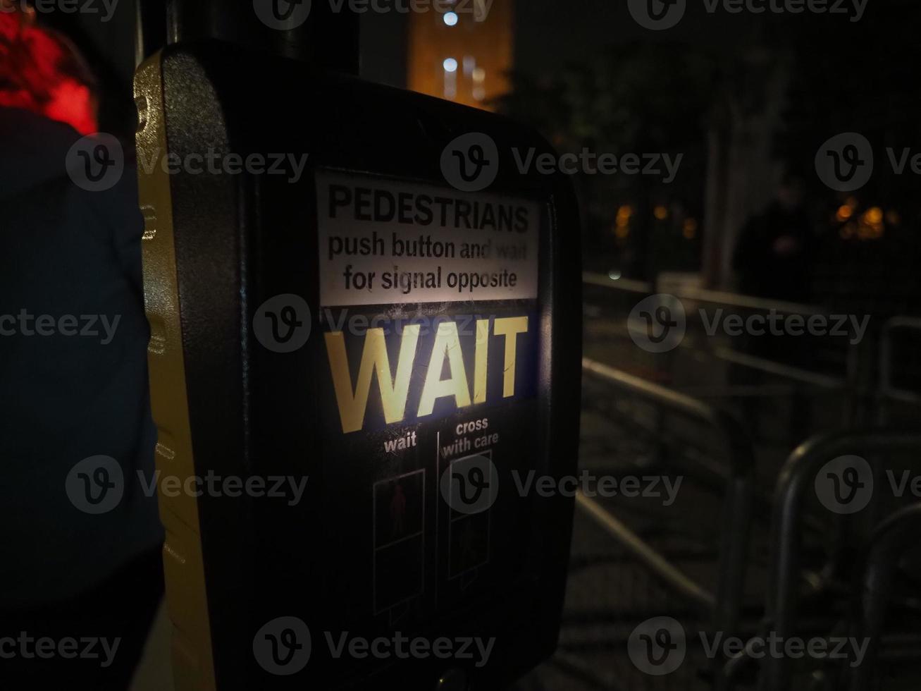 esperar placa às pedestre cruzando às noite dentro Londres foto