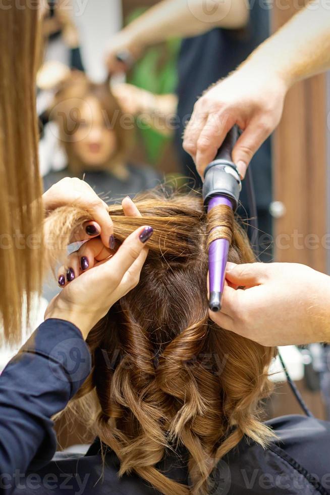 cabeleireiro faz Penteado de ondulação ferro foto