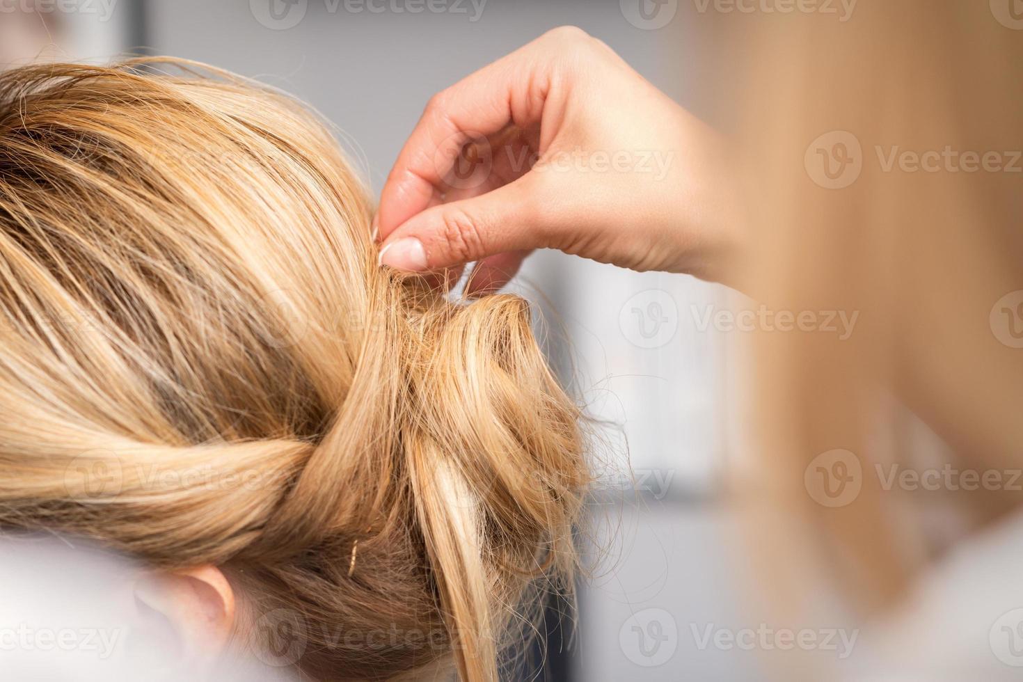 cabeleireiro faz Penteado do jovem mulher foto