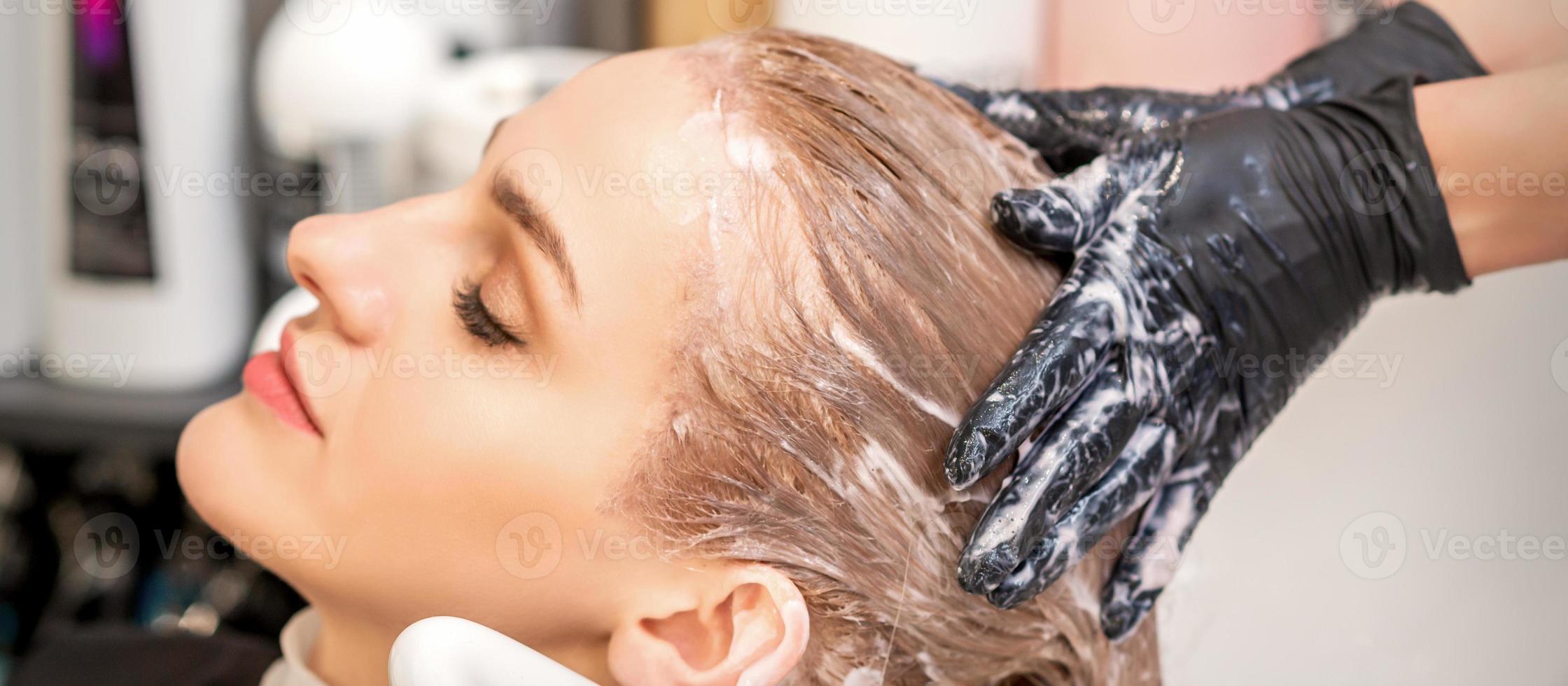 jovem mulher recebendo cabelo lavar foto