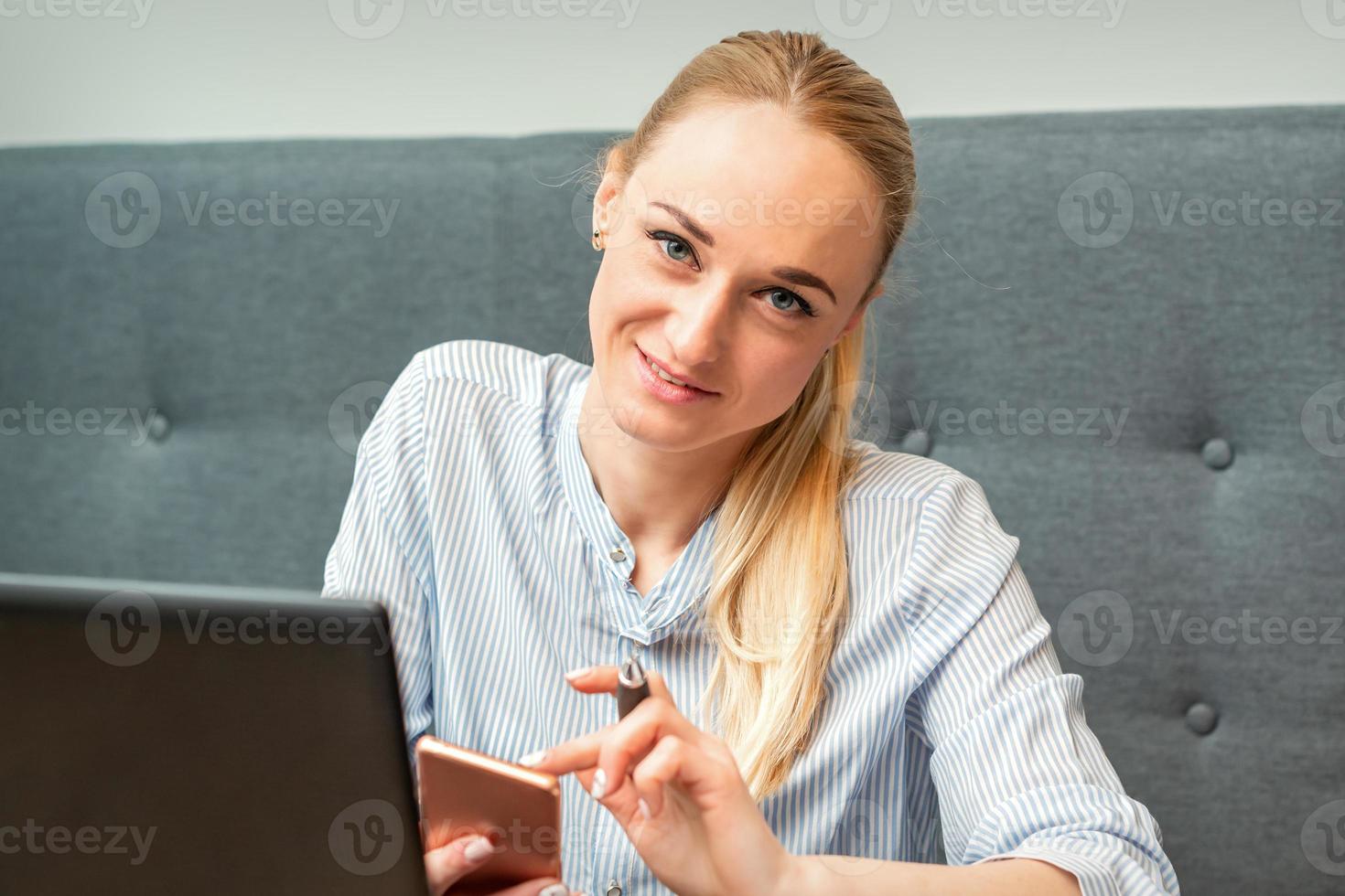 empresária com Smartphone trabalhando dentro escritório foto