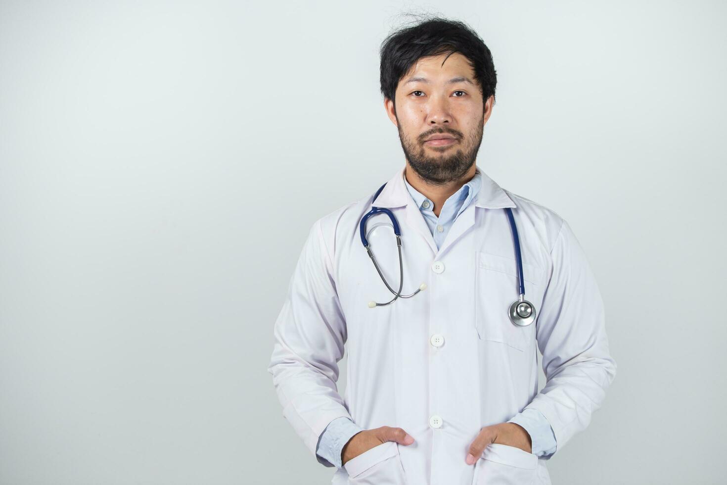 ásia homem dentro médico uniforme em branco fundo dentro hospital foto