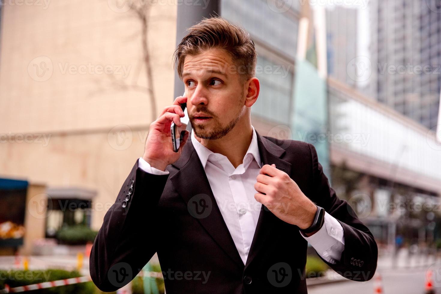 retrato do uma jovem homem de negocios dentro uma o negócio Centro falando em a telefone foto