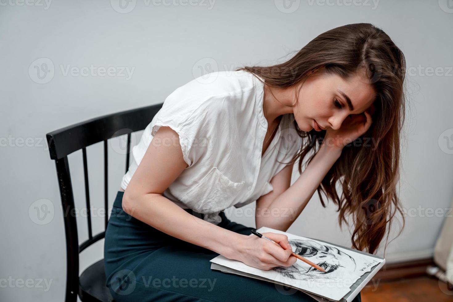 menina sentado em uma cadeira desenha uma esboço para uma cenário foto