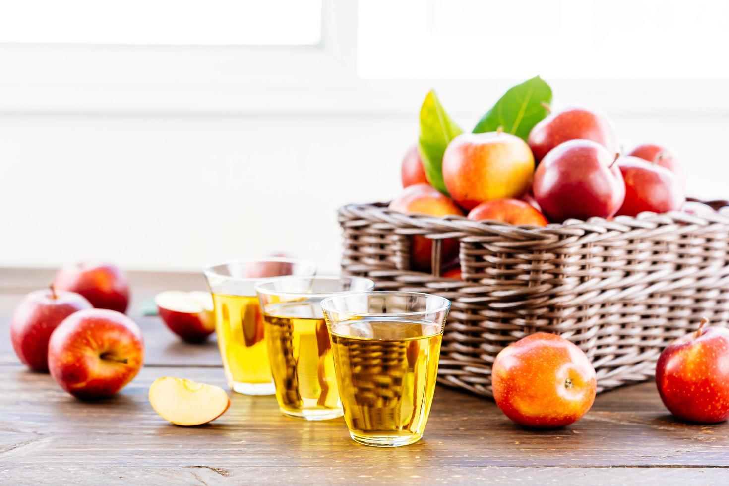 suco de maçã em copos e maçãs na cesta foto