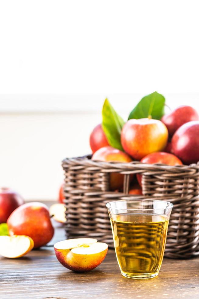 suco de maçã no copo e maçãs na cesta foto