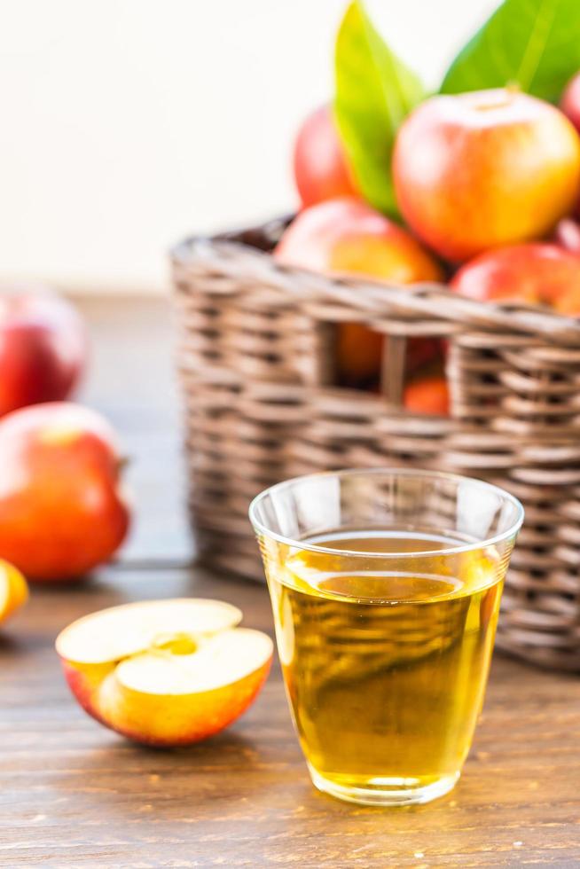 suco de maçã no copo e maçãs na cesta foto