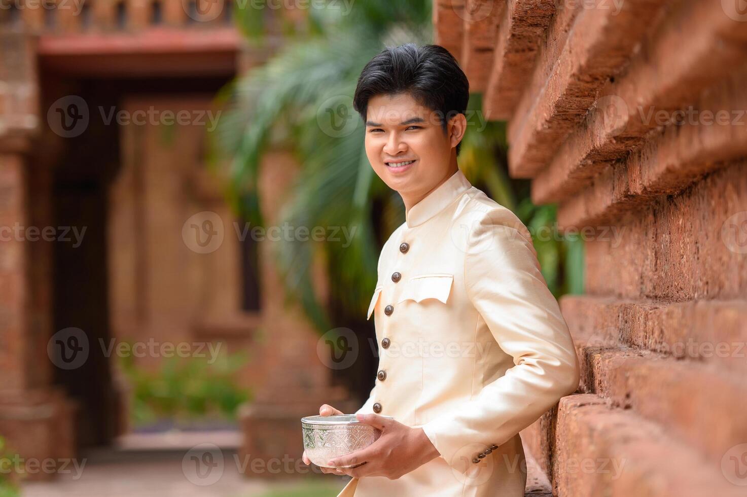 retrato homem bonito no festival songkran com tigela de água foto