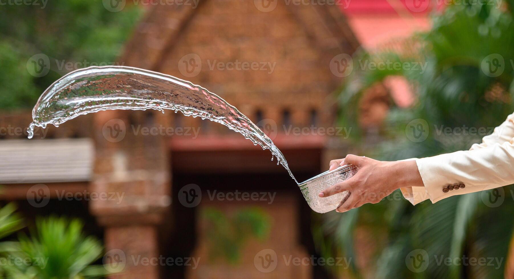 jovem espirrando água da tigela no festival songkran foto