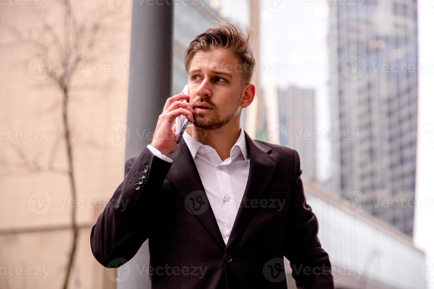 retrato do uma jovem homem de negocios dentro uma o negócio Centro falando em a telefone foto