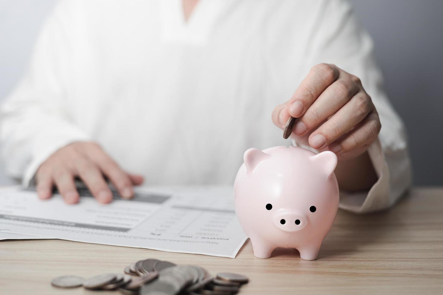 homem de negocios colocando moeda em a cofrinho em mesa, família finança plano conceito, angariação de fundos, aposentadoria, doação, salvando, caridade, investimento, financeiro crise conceito. foto