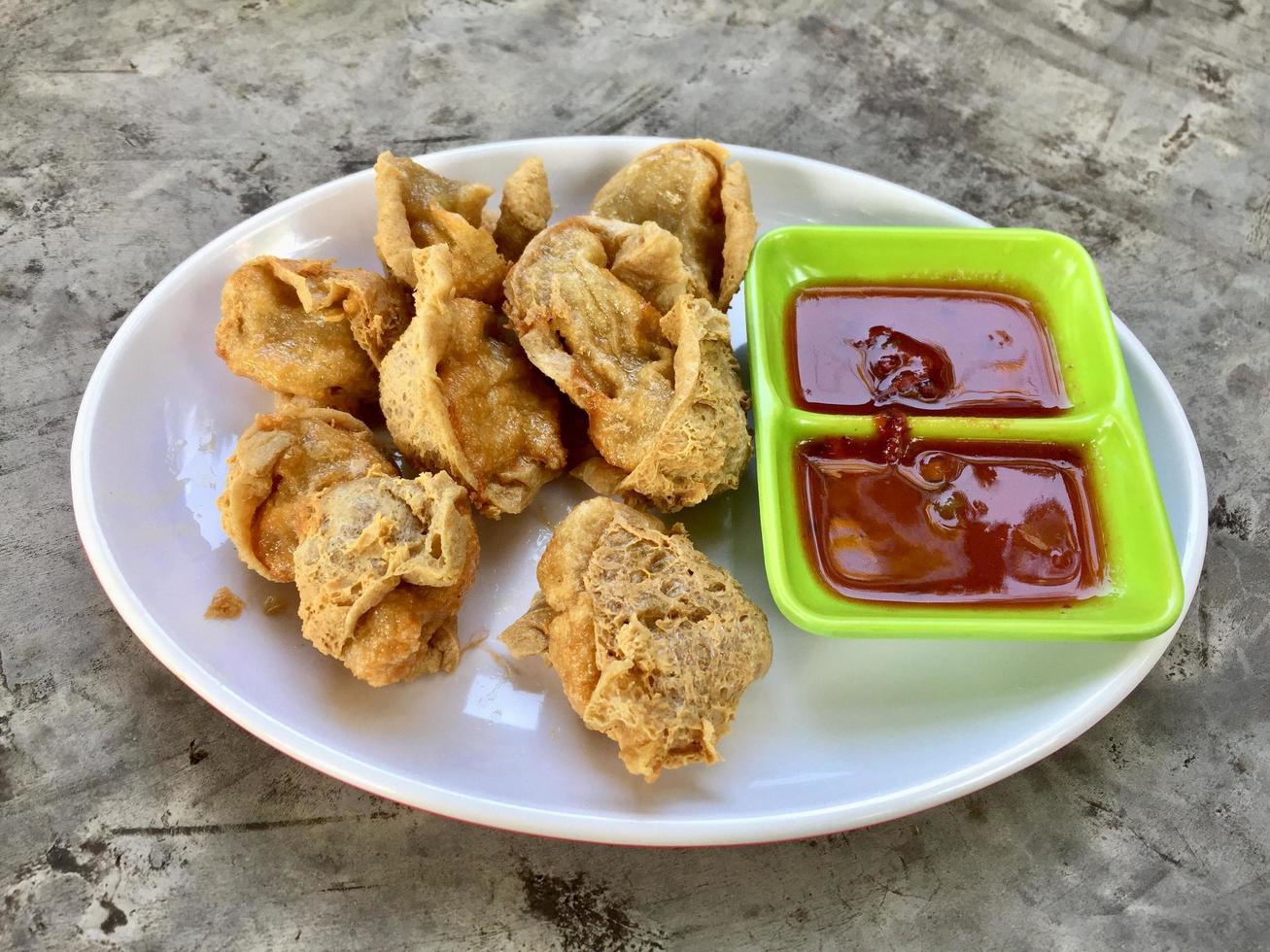 uma prato do frito tofu com molho em uma verde prato foto