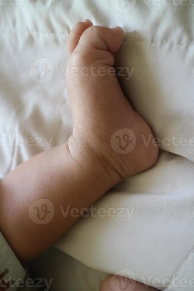 fofa pés do uma recém-nascido bebê em uma branco colchão foto