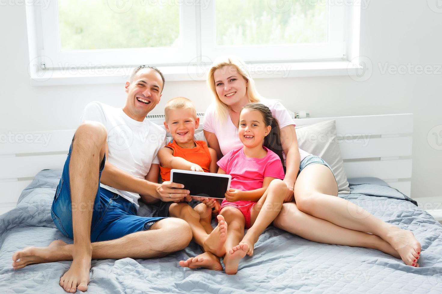 lindo sorridente multético família dentro frente do a computador portátil vídeo ligar com distante pais às lar. foto