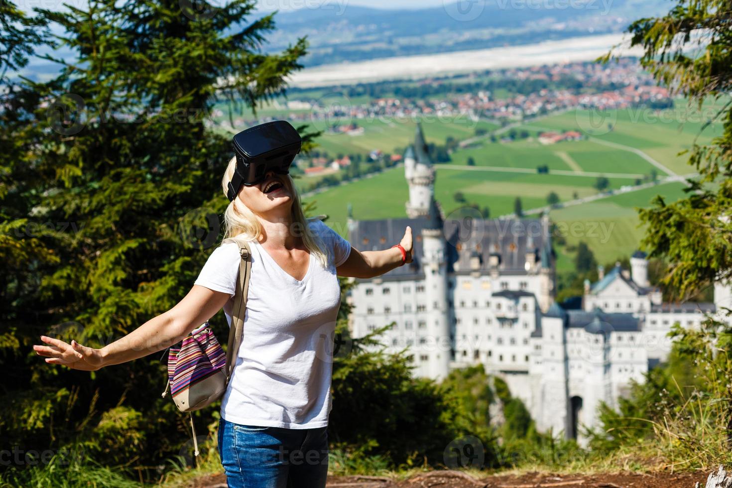 uma viajante com virtual realidade óculos. a conceito do virtual viagem por aí a mundo. dentro a fundo castelo neuschwanstein. futuro tecnologia conceito. foto