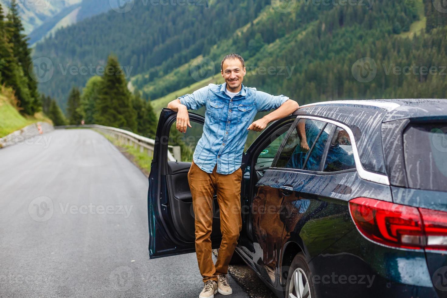 viagem, turismo, estrada viagem, transporte e pessoas conceito - feliz homem perto carro sobre montanhas fundo foto