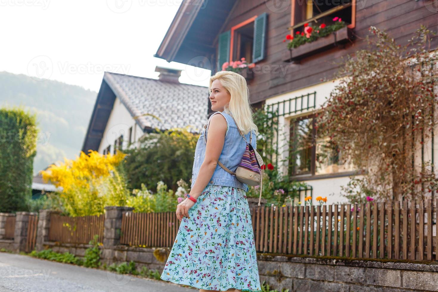 jovem mulher é em pé de de madeira casas. Vila dentro montanhas. viagem, estilo de vida conceito. Alpes, Europa. foto