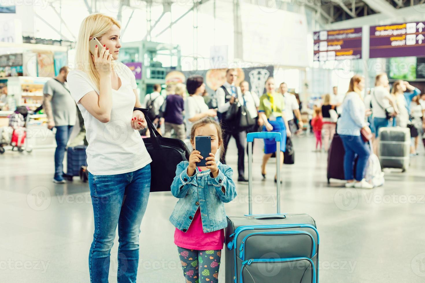 família dentro aeroporto. atraente jovem mulher e fofa pequeno filha estão pronto para viajando feliz família conceito. foto