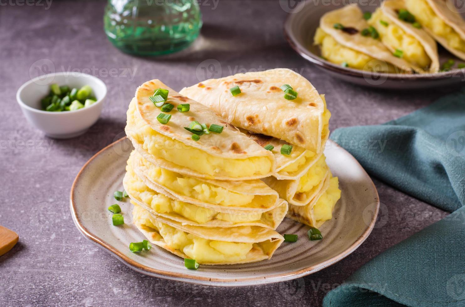 uma pilha do kystyby - fino pão sírio preenchidas com amassado batatas e cebolas em uma placa. foto